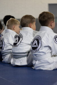 The back of Roger Gracie Bristol students sat in line watching the coaches teach the technique.